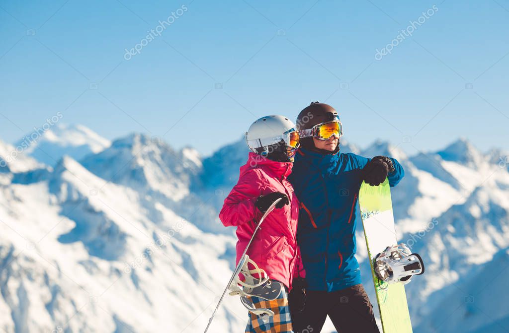 Happy couple of snowboarders in the alpine mountains