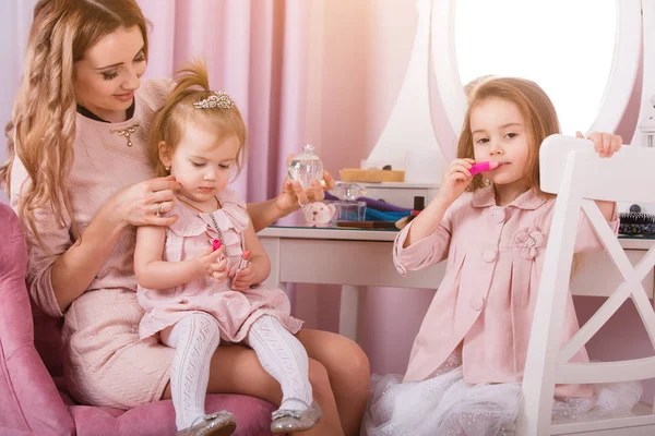 Mãe e duas filhas fazendo maquiagem labial . — Fotografia de Stock