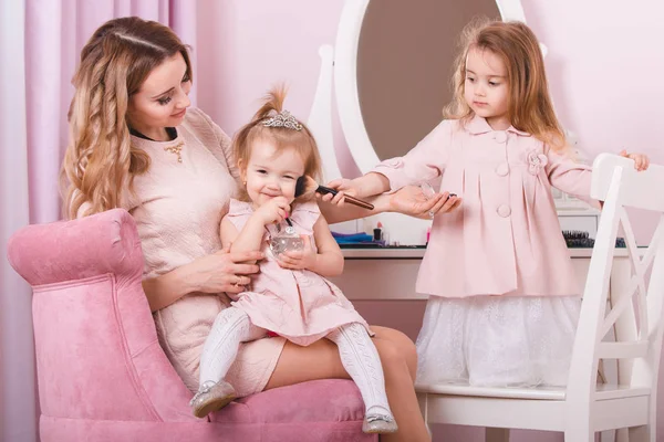 Mãe e duas filhas fazendo maquiagem labial . — Fotografia de Stock