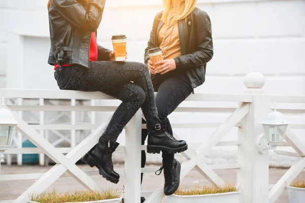 Porträtt av två vackra unga flickvänner med papper koppar kaffe i händer. — Stockfoto