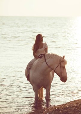 Sahilde atı ile beyaz elbiseli kız