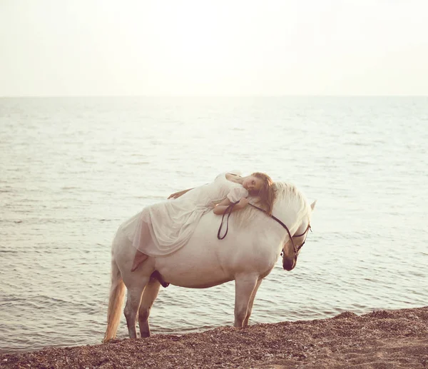 Menina em vestido branco com cavalo na praia — Fotografia de Stock