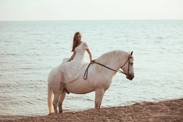 Menina em vestido branco com cavalo na praia — Fotografia de Stock