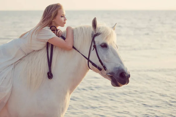 Menina em vestido branco com cavalo na praia — Fotografia de Stock