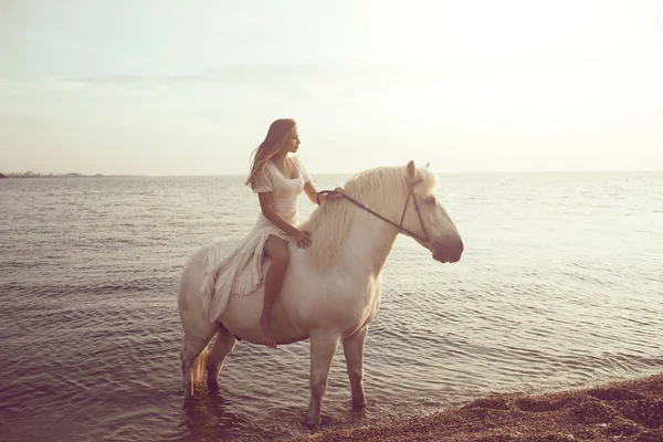 Menina em vestido branco com cavalo na praia — Fotografia de Stock