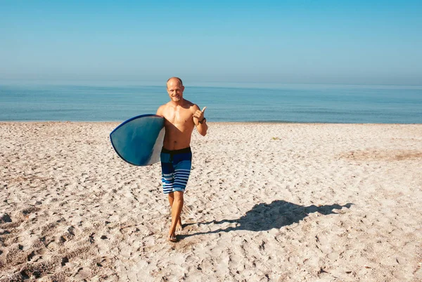 Surfista vai surfar no oceano num dia ensolarado — Fotografia de Stock