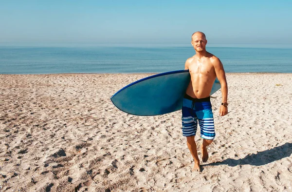 Surfista vai surfar no oceano num dia ensolarado — Fotografia de Stock