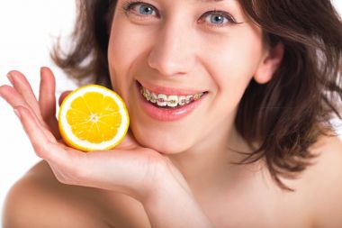 Mükemmel cilt ve çok renkli ayraçlar Palm'da limonlu poz ile güzel kız