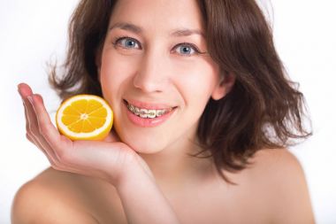 Mükemmel cilt ve çok renkli ayraçlar Palm'da limonlu poz ile güzel kız