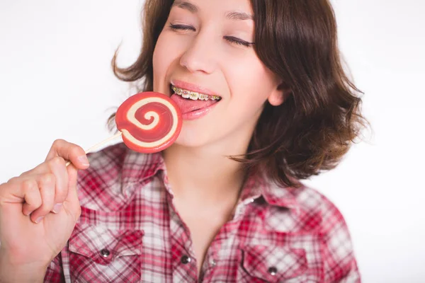 Close-up shot of girl with multicolored bracket systems and lollipop — Stock Photo, Image