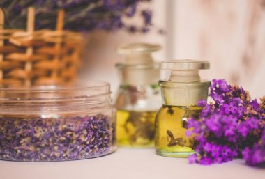 Ahşap arka plan üzerinde taze çiçekler ile lavanta yağı.