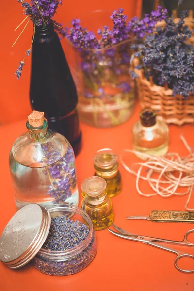 Olio di lavanda con fiori freschi sul tavolo arancione — Foto Stock