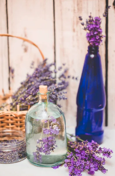 Лавандова олія зі свіжими квітами на дерев'яному фоні . — стокове фото