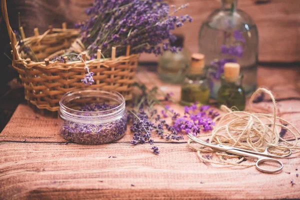 Olio di lavanda con fiori freschi su sfondo di legno . — Foto Stock