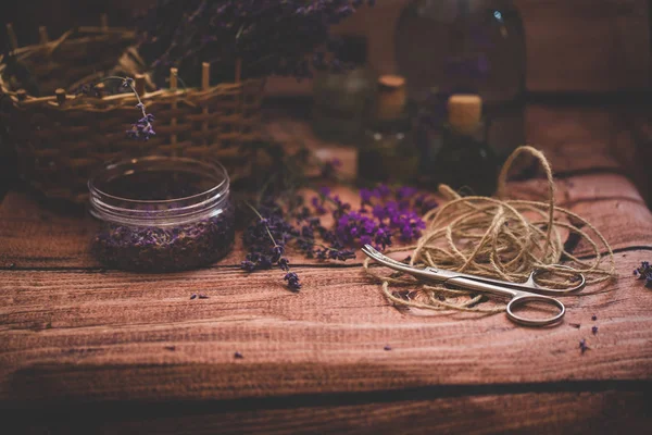 Olio di lavanda con fiori freschi su sfondo di legno . — Foto Stock