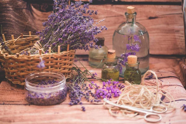 Olio di lavanda con fiori freschi su sfondo di legno . — Foto Stock