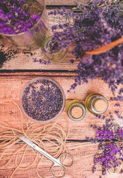 Olio di lavanda con fiori freschi su sfondo di legno . — Foto Stock