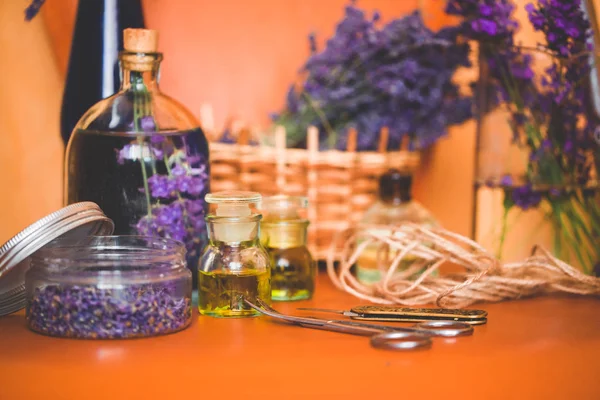 Olio di lavanda con fiori freschi sul tavolo arancione — Foto Stock