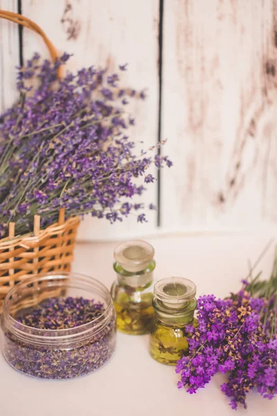 Olio di lavanda con fiori freschi su sfondo di legno . — Foto Stock