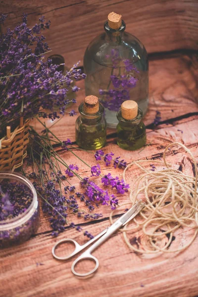 Лавандова олія зі свіжими квітами на дерев'яному фоні . — стокове фото