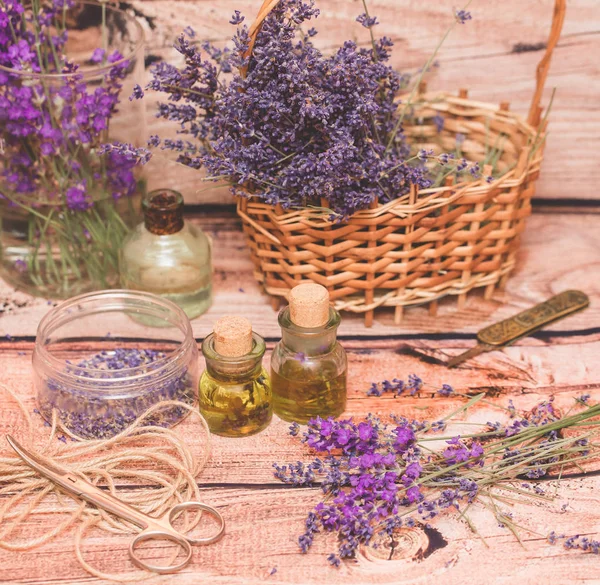 Olio di lavanda con fiori freschi su sfondo di legno . — Foto Stock