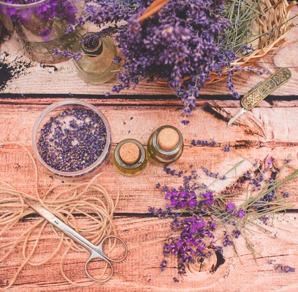 Olio di lavanda con fiori freschi su sfondo di legno . — Foto Stock