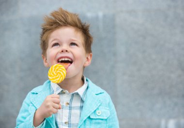 Lolipop gri duvarının yakınında olan moda çocuk