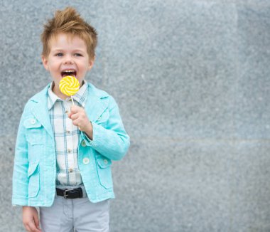 Lolipop gri duvarının yakınında olan moda çocuk