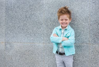 Moda çocuk gri duvara yakın poz