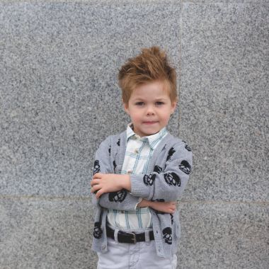 Moda çocuk gri duvara yakın poz