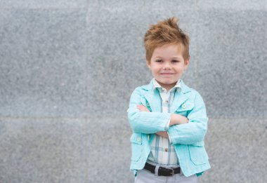Moda çocuk gri duvara yakın poz