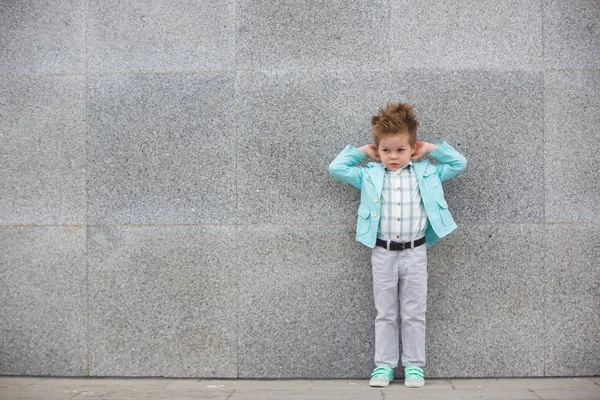 Moda bambino posa vicino muro grigio — Foto Stock