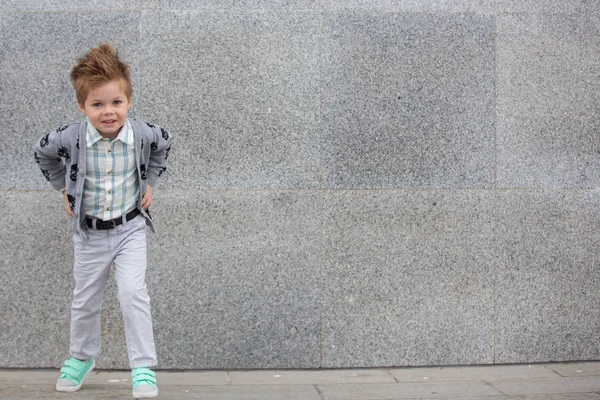 Moda bambino posa vicino muro grigio — Foto Stock