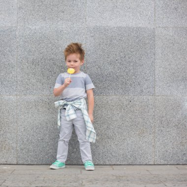 Moda çocuk gri duvarının yakınında