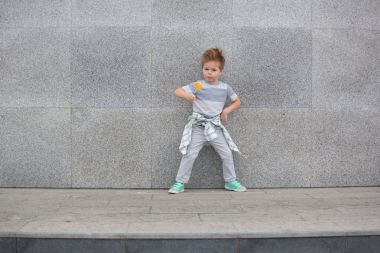 Moda çocuk gri duvarının yakınında