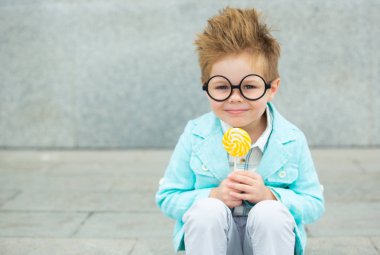 Lolipop gri duvarının yakınında olan moda çocuk