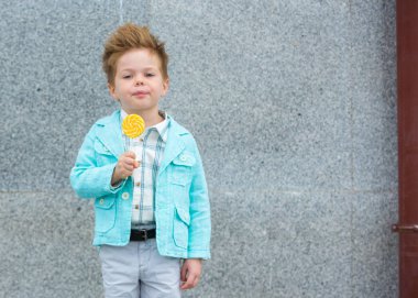 Lolipop gri duvarının yakınında olan moda çocuk