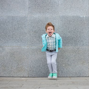 Moda çocuk gri duvara yakın poz