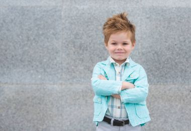 Moda çocuk gri duvara yakın poz