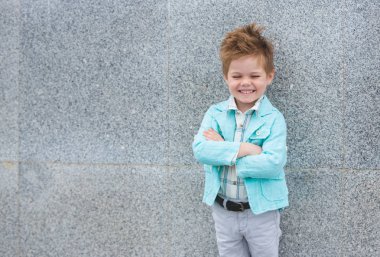 Moda çocuk gri duvara yakın poz