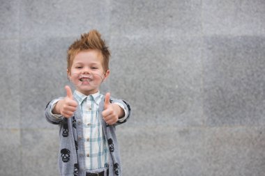 Gri duvarının yakınında gözlüklü moda çocuk