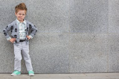 Gri duvarının yakınında gözlüklü moda çocuk