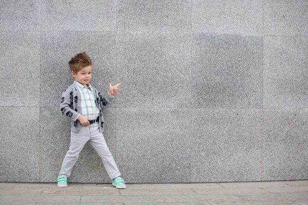 Moda bambino posa vicino muro grigio — Foto Stock