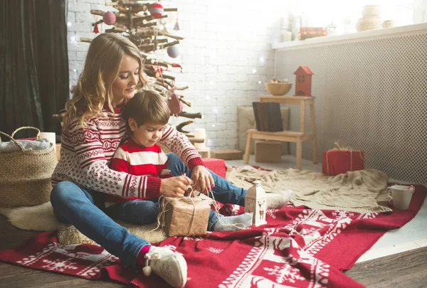 Retrato de mãe e filho feliz no fundo da árvore de Natal no quarto de ano novo. A ideia de cartões postais — Fotografia de Stock