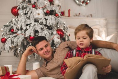 Father and son reading book on Christmas