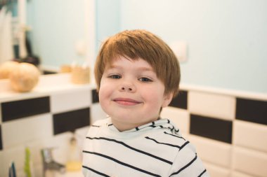 Küçük çocuk dişlerini fırçalıyor.