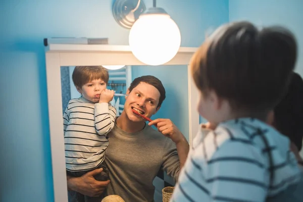 Jovem pai com seu filho escovando os dentes — Fotografia de Stock