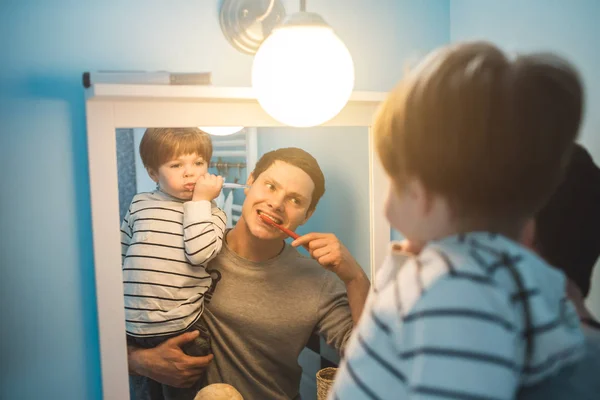 Молодий батько з сином чистить зуби — стокове фото