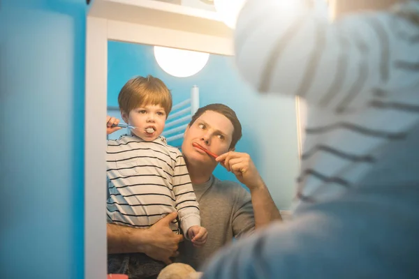 Jovem pai com seu filho escovando os dentes — Fotografia de Stock