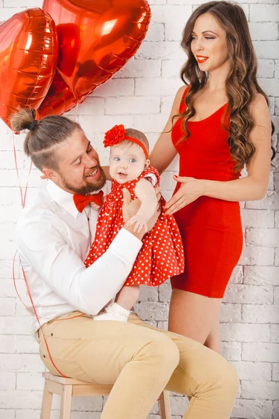 Happy young family mother, father and daughter posing in studio. — Stock Photo, Image